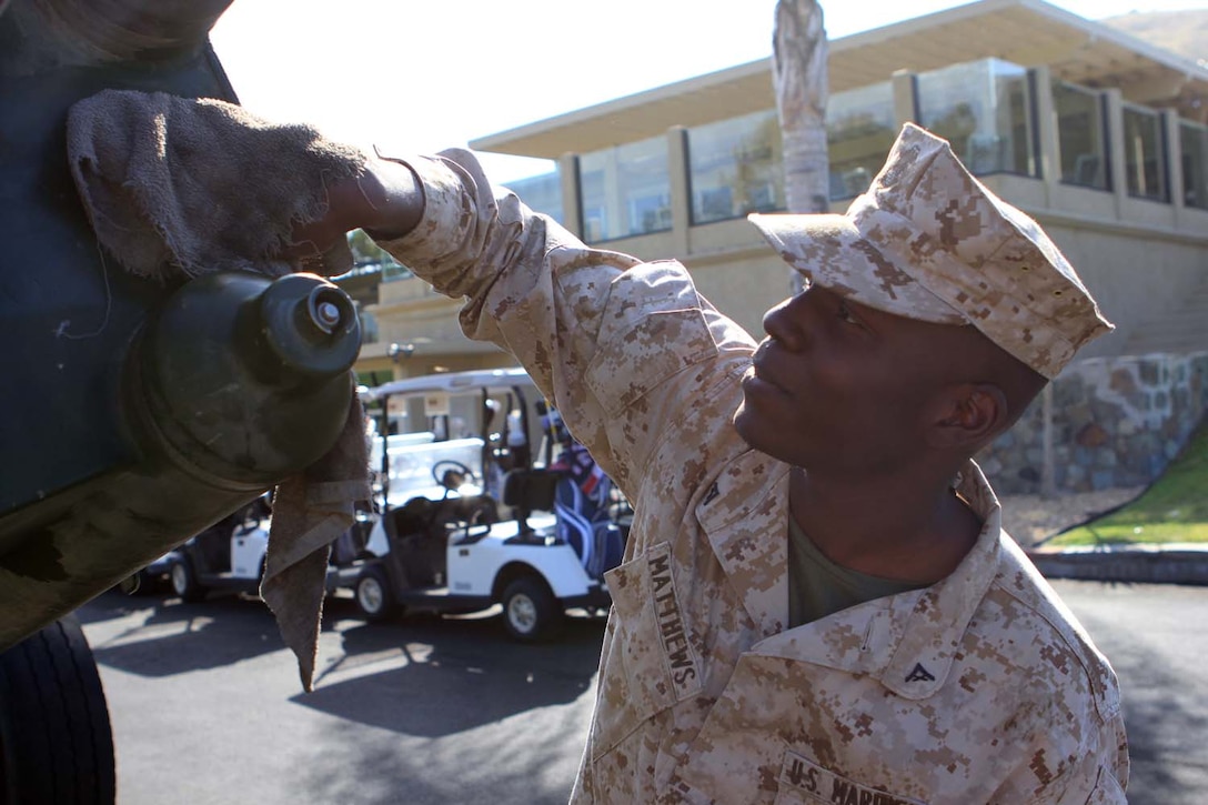 Lance Cpl. John Matthews, a cannoneer serving with Kilo Battery, 2nd Battalion, 11th Marine Regiment, and Phoenix native, polishes an M777 Howitzer staged as a static display for the Commanding General's 2nd Invitational Golf Tournament at the Marine Memorial Golf Course here, May 14, 2013. The tournament provided a unique opportunity for Marines and sailors to network and share experiences with business and community leaders as well as golf industry experts. Each of the 18 holes on the course gave the participants challenges, varying from wearing a flak jacket to playing with alcohol impairment goggles. The intent of the invitational was to highlight facilities aboard the base that are accessible to civilians and provide information about the installation to invited guests.