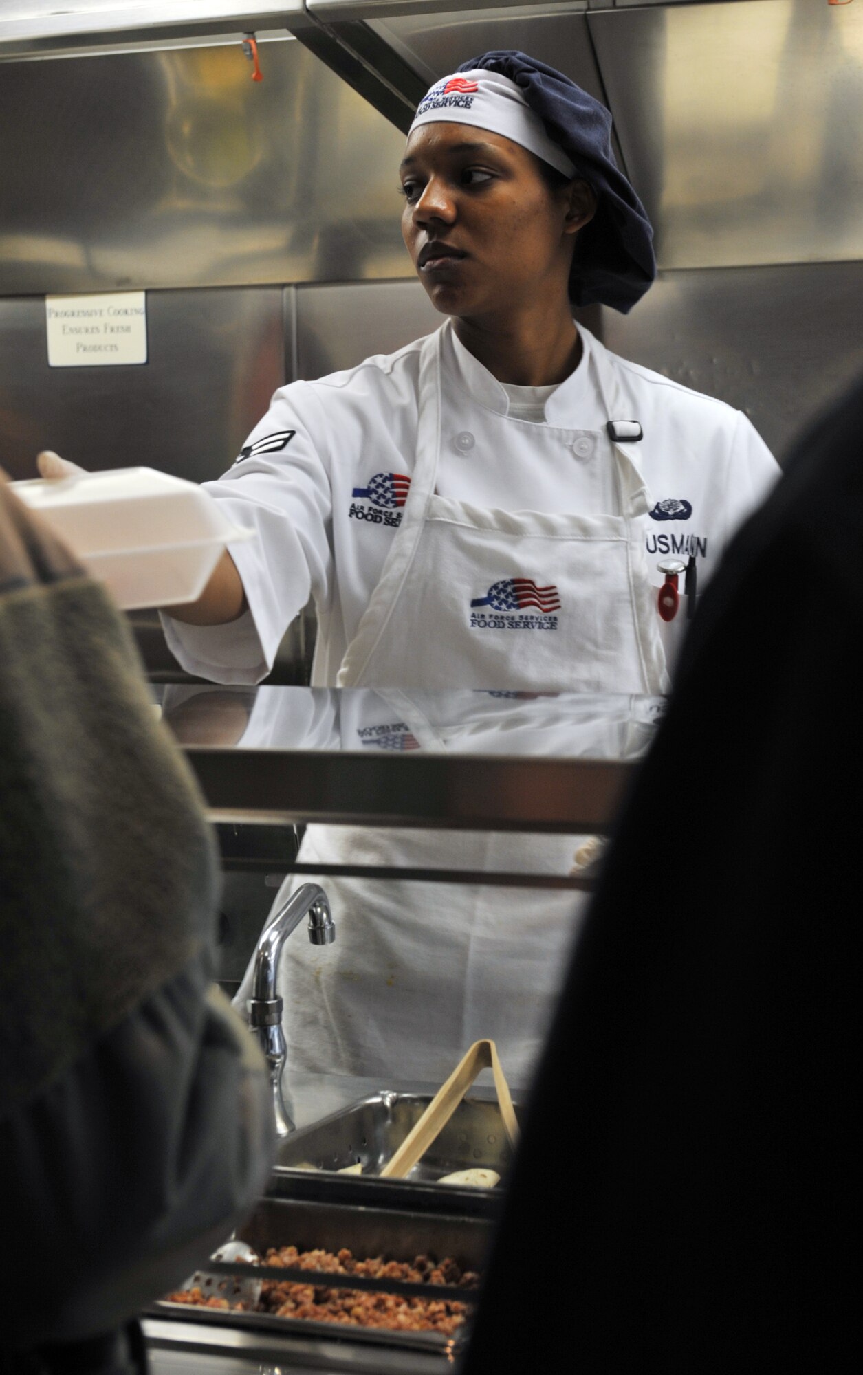 Airman 1st Class Nicole Klusmann, 509th Force Support Squadron food service specialist, delivers a to-go box to a customer during her shift at the Touch N’ Go In-Flight Kitchen at Whiteman Air Force Base, Mo., April 3, 2013. The 509th FSS was just named as winner of the John L. Hennessy Trophy, awarded to the best dining facility in the Air Force. (U.S. Air Force photo by Heidi Hunt/Released)