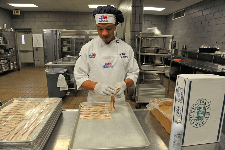 Airman 1st Class Curtis Esquibel, 509th Force Support Squadron services apprentice, prepares bacon at the Ozark Inn on Whiteman Air Force Base, Mo. April 15, 2013. The 509th FSS was named as the John L. Hennessy Trophy winner, which is awarded to the Air Force’s best food service unit. (U.S. Air Force photo by Airman 1st Class Keenan Berry/Released)