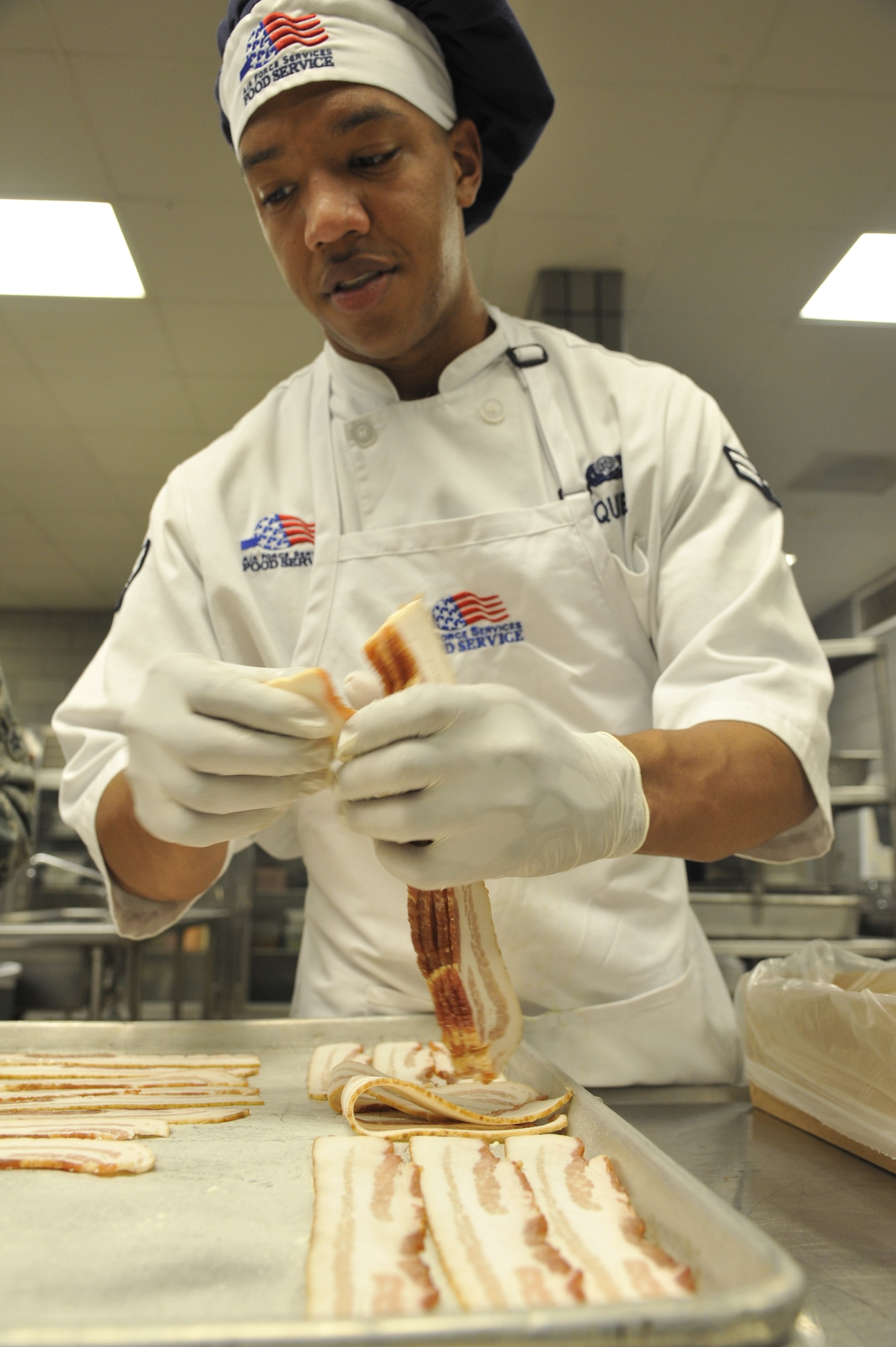 Airman 1st Class Curtis Esquibel, 509th Force Support Squadron services apprentice, prepares bacon at the Ozark Inn on Whiteman Air Force Base, Mo., April 15, 2013. The 509th FSS was named as the John L. Hennessy Trophy winner, which is awarded to the Air Force’s best food service unit. (U.S. Air Force photo by Airman 1st Class Keenan Berry/Released)
