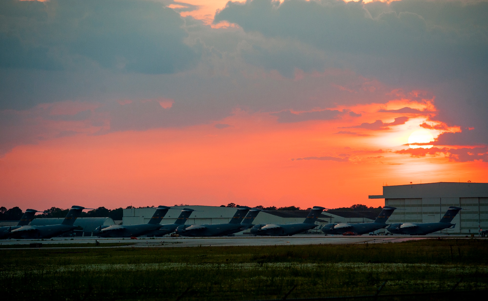 C-17 Globemaster III’s sit on the flightline as the sun sets May 9, 2013, at Joint Base Charleston – Air Base, S.C. The C-17 is capable of rapid strategic delivery of troops and all types of cargo to main operating bases or directly to forward bases in the deployment area. The aircraft can perform tactical airlift and airdrop missions and can transport litters and ambulatory patients during aeromedical evacuations when required. (U.S. Air Force photo/ Senior Airman Dennis Sloan)