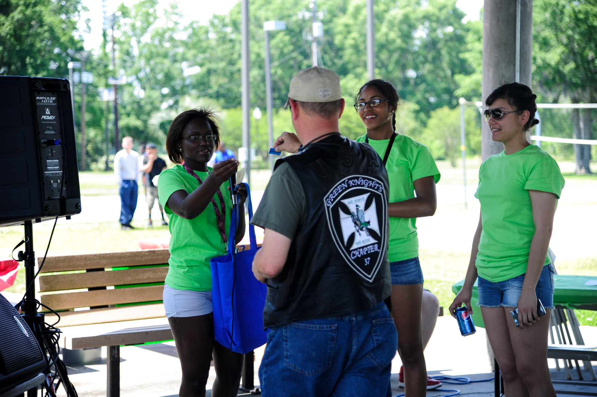 Airmen give out a prize to a member of the Green Knights Military Motorcycle Club, during a raffle ticket drawing at the Dorm Tailgate Party May 10, 2013, at Joint Base Charleston - Air Base, S.C. Organizations like the Green Knights MMC were at the event to provide supportive mentorship and to offer volunteer opportunities for Airmen to take advantage of in their local community. The Tailgate Party was designed to strengthen social ties among dorm members and enhance their esprit de corps and was sponsored by the Single Airman's Initiative Program and the Air Force Sergeants Association, and included a dirty truck competition, a hot dog eating contest, a basketball tournament and a live DJ. (U.S. Air Force photo/Staff Sgt. Rasheen Douglas)