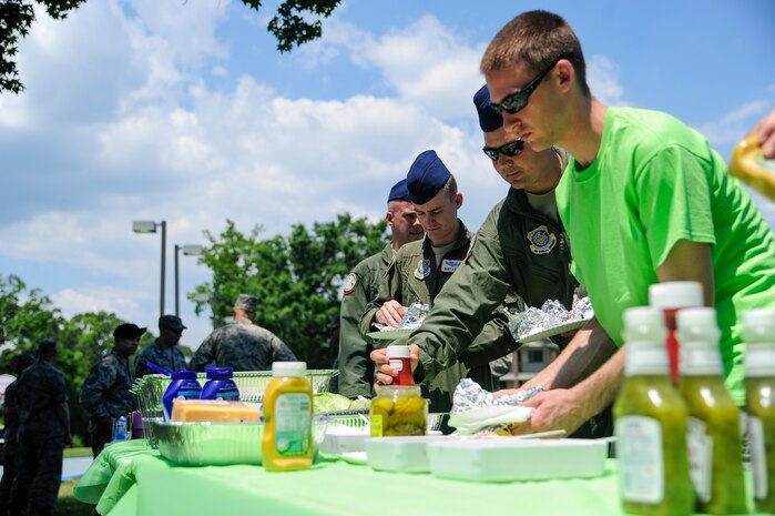 Dorm residents make their way through a buffet line during the Dorm Tailgate Party May 10, 2013, at Joint Base Charleston - Air Base, S.C. The Tailgate Party was designed to strengthen social ties among dorm members and enhance their esprit de corps. The party was sponsored by the Single Airman's Initiative Program and the Air Force Sergeants Association, and included a dirty truck competition, a hot dog eating contest, a basketball tournament and a live DJ.  (U.S. Air Force photo/Staff Sgt. Rasheen Douglas)