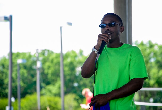Senior Airman Derrick Alston, 437th Aircraft Maintenance Squadron crew chief, announces the schedule of upcoming events during the Dorm Tailgate Party May 10, 2013, at Joint Base Charleston - Air Base, S.C. The Tailgate Party was designed to strengthen social ties among dorm members and enhance their esprit de corps. The party was sponsored by the Single Airman's Initiative Program and the Air Force Sergeants Association, and included a dirty truck competition, a hot dog eating contest, a basketball tournament and a live DJ. (U.S. Air Force photo/Staff Sgt. Rasheen Douglas)