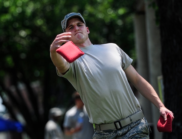 Staff Sgt. Eric Genther, 628th Civil Engineer Squadron structures craftsman, tosses a bean bag during a game of cornhole at the Dorm Tailgate Party May 10, 2013, at Joint Base Charleston - Air Base, S.C. The Tailgate Party was designed to strengthen social ties among dorm members and enhance their esprit de corps. The party was sponsored by the Single Airman's Initiative Program and the Air Force Sergeants Association, and included a dirty truck competition, a hot dog eating contest, a basketball tournament and a live DJ. (U.S. Air Force photo/Staff Sgt. Rasheen Douglas)