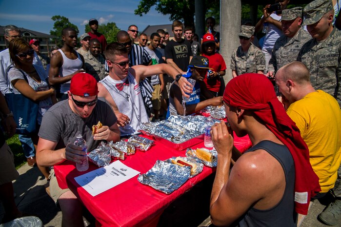 Contestants rush to eat as many hot dogs as they can during the Dorm Tailgate Party Hot Dog Eating contest May 10, 2013, at Joint Base Charleston – Air Base, S.C. The Tailgate Party was designed to strengthen social ties among dorm members and enhance their esprit de corps. The party was sponsored by the Single Airman's Initiative Program and the Air Force Sergeants Association, and included a dirty truck competition, a hot dog eating contest, a basketball tournament and a live DJ. (U.S. Air Force photo/ Senior Airman George Goslin)