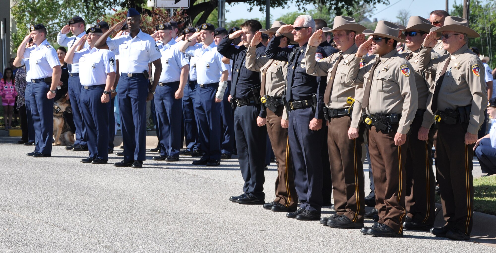 SAN ANGELO, Texas- Members from the San Angelo Police Department and the 17th Security Forces Squdron salute the flag as it is raised at the SAPD, May 13. The flag ceremony was held as part of National Police Week to honor those lost in the line of duty and law enforcement officers everywhere. (U.S. Air Force photo/ Airman 1st Class Erica Rodriguez)