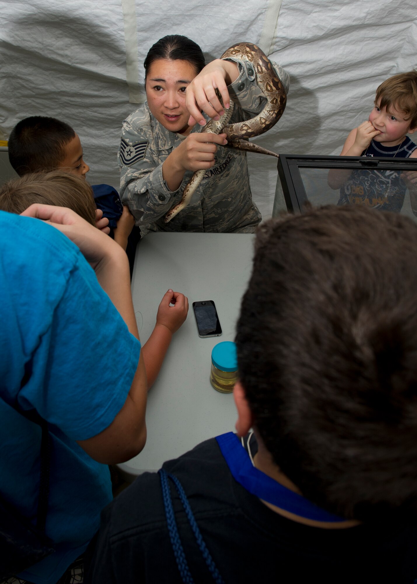 Tech. Sgt. Tina Simpson, 49th Aerospace Medicine Squadron public health technician, shows “deployers” Mr. Snake, a critter that can be found in deployed locations, at “Bearghanistan” during Operation Kids Investigating Deployment at Holloman Air Force Base, N.M., May 13. The “deployers” experienced a recall, deployment line, deployment to “Bearghanistan,” and welcome home. (U.S. Air Force photo by Senior Airman Kasey Close/Released)