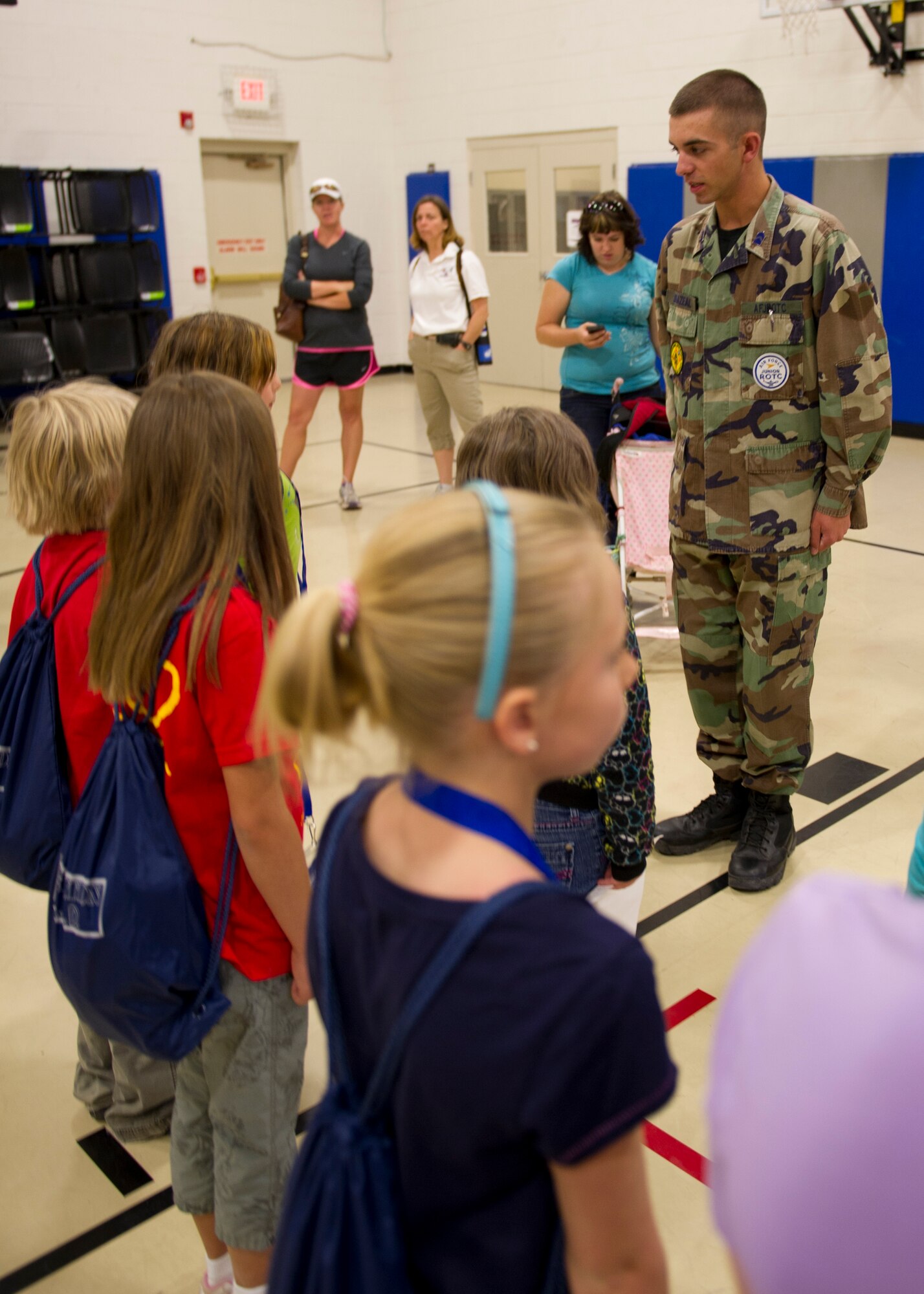 Cadet 2nd Lt. Tyler Odom, Air Force Junior Reserve Officer Training Corps, teaches “deployers” how to stand at attention for when the commander comes in the Youth and Teen Center during Operation Kids Investigating Deployment at Holloman Air Force Base, N.M., May 13. The “deployers” experienced a recall, deployment line, deployment to “Bearghanistan,” and welcome home. (U.S. Air Force photo by Senior Airman Kasey Close/Released)