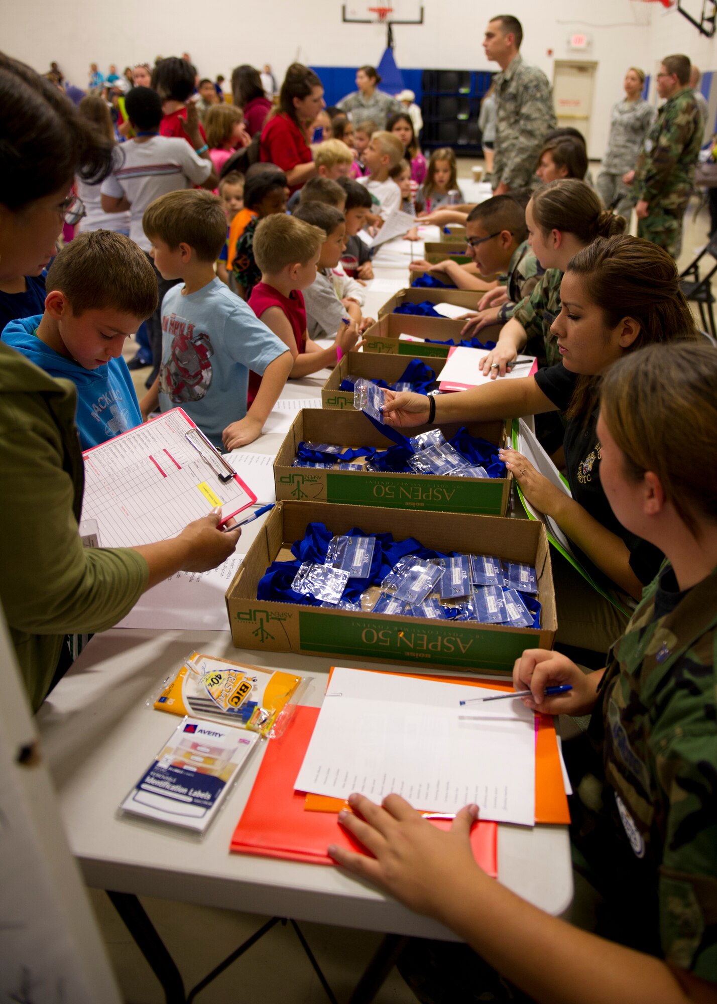 Air Force Junior Reserve Officer Training Corps members issue ID cards and orders to the “deployers” at the Youth and Teen Center during Operation Kids Investigating Deployment at Holloman Air Force Base, N.M., May 13. The “deployers” were also divided into nine chalks to go through the deployment processing line. (U.S. Air Force photo by Senior Airman Kasey Close/Released)