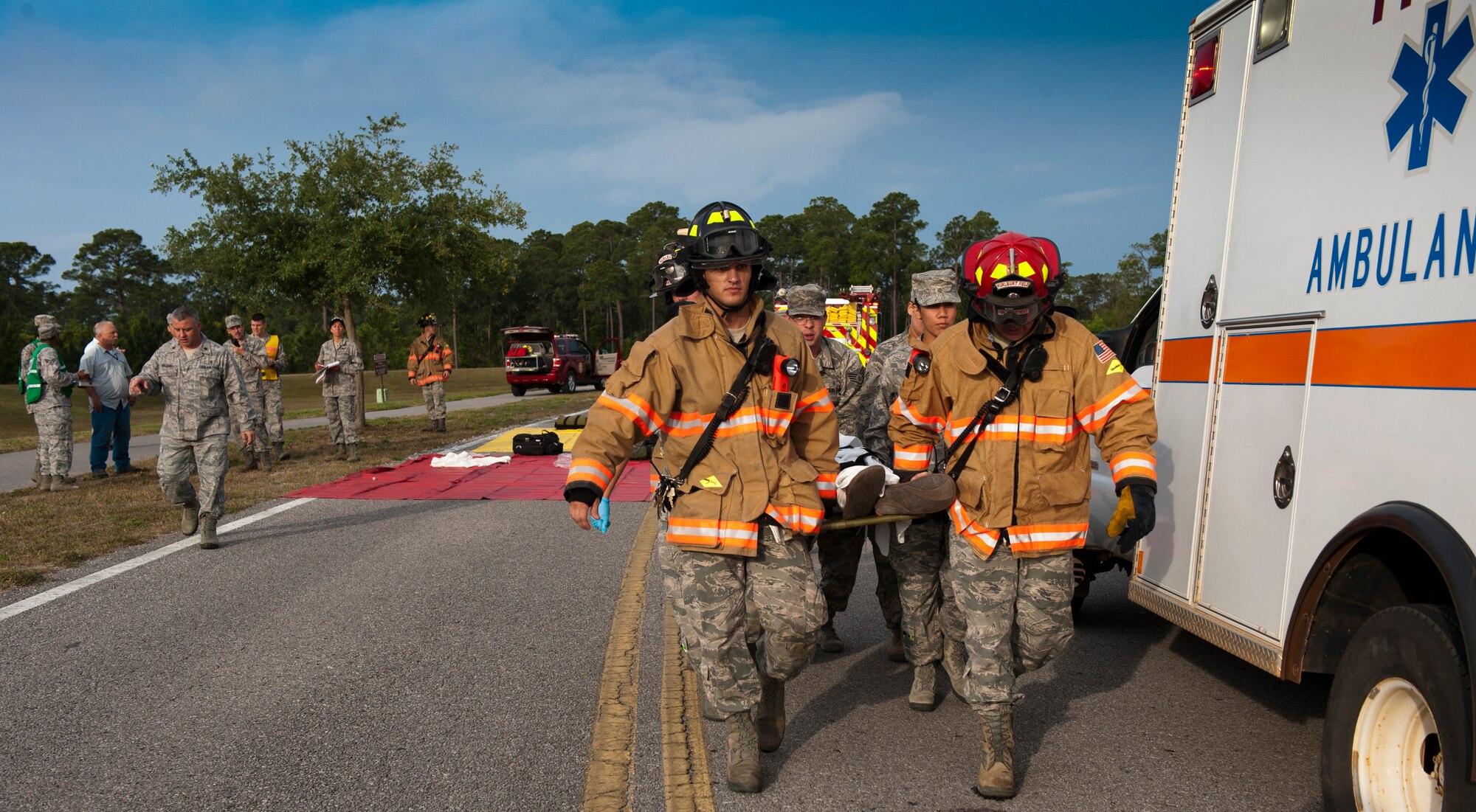Firefighters from the 1st Special Operations Civil Engineer Squadron transport mock-contaminated victims to an ambulance during a Chemical, Biological, Radiological, Nuclear and Explosive response training on Hurlburt Field, Fla., May 10, 2013. Fire department personnel assessed and placed the injured on tarps, depending on their injuries, and quickly provided appropriate treatment to each casualty once medical personnel arrived. (U.S. Air Force photo by Senior Airman Krystal M. Garrett) 