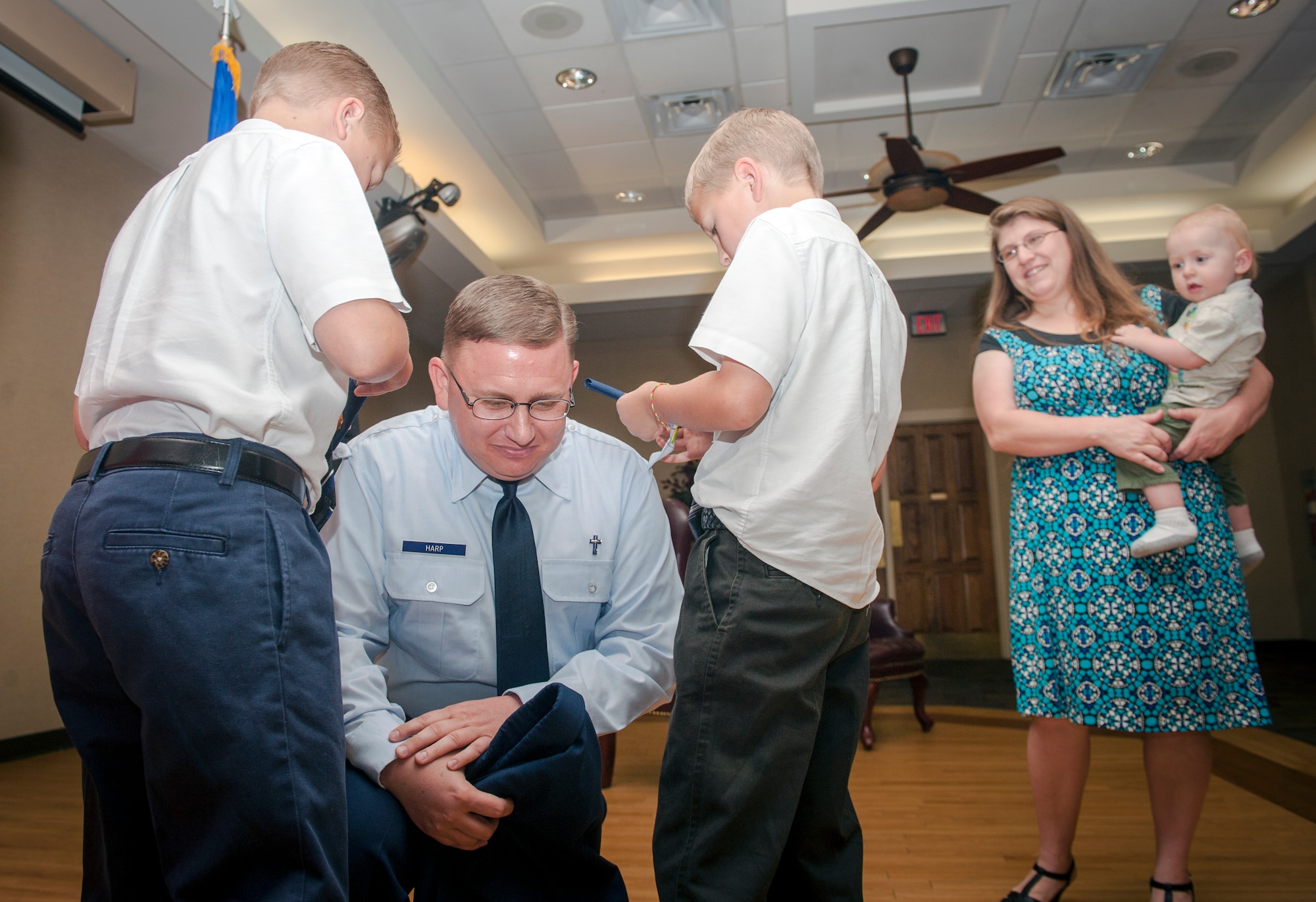 U.S. Air Force Chaplain (Maj.) Erik Harp, 93d Air Ground Operations Wing chaplain, kneels as his sons pin on his new rank during his promotion ceremony at Moody Air Force Base, Ga., April 30, 2013. Harp enlisted in the Air Force and served as a chaplain assistant before earning a master’s degree, a commission and appointment as a chaplain. (U.S. Air Force photo by Senior Airman Jarrod Grammel/Released)
