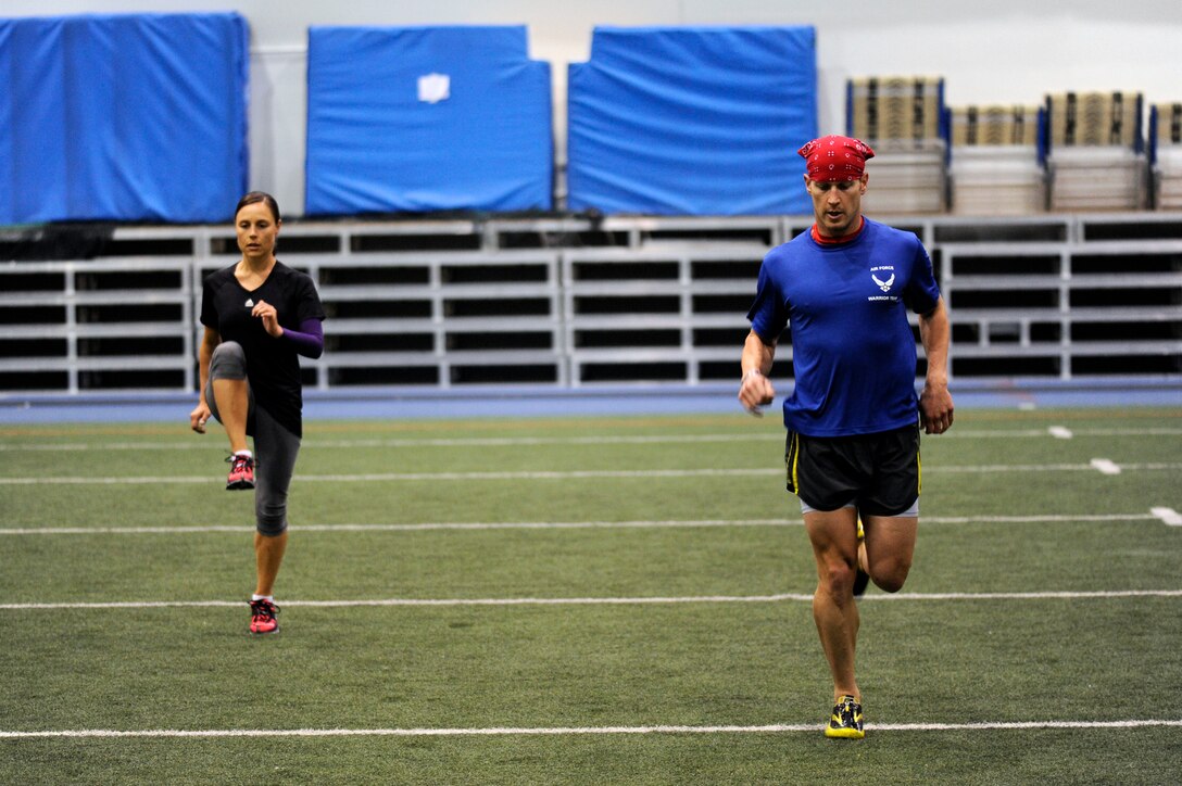 Capt. Mitchell Kieffer and Staff Sgt. Lara Ishikawa warm up before running laps at the Academy indoor track during the Wounded Warrior Games Training Camp held in Colorado Springs, Colo., April 17, 2013. (U.S. Air Force photo/Desiree N. Palacios)