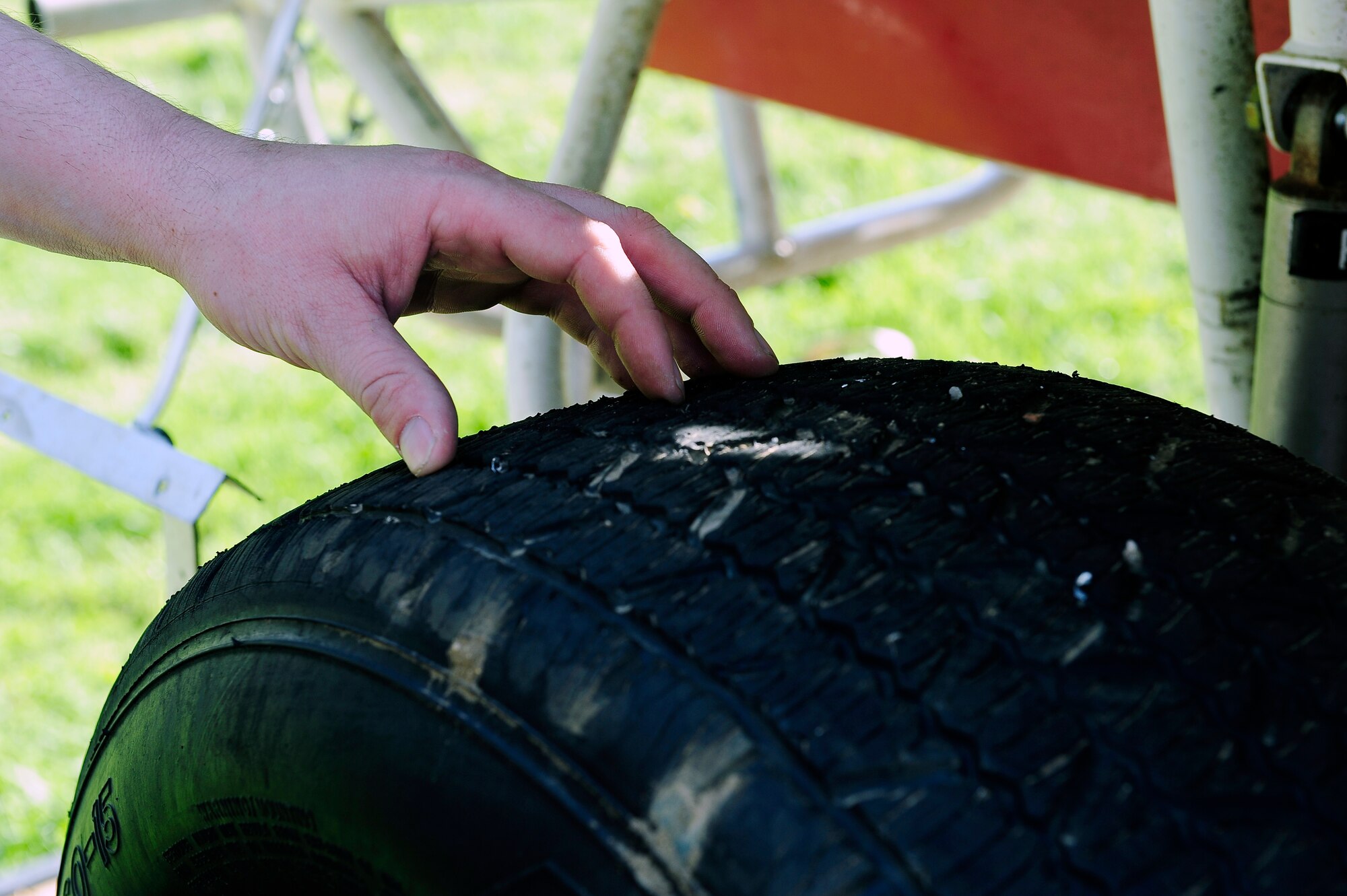 Staff Sgt. Chris Brockway, 442nd Logistics Readiness Squadron traffic management office apprentice, examines the right rear tire of his B-Modified racecar in Warrensburg, Mo., April 29, 2013. The tires are cut with certain grooves to improve traction on the dirt racetracks he races at. (U.S. Air Force photo by Airman 1st Class Shelby R. Orozco/Released)