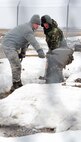 MINOT AIR FORCE BASE, N.D. -- Airmen from the 91st Maintenance Group shovel snow at a missile launch facility here, April 30. The work was part of an ongoing fight to ensure the sites do not become flooded during warmer spring weather.  Two years ago, flood damage caused three missiles to be removed and sent to the Intercontinental Ballistic Missile Depot at Hill AFB, Utah, for refurbishment. (U.S. Air Force photo/Senior Airman Brittany Y. Auld)