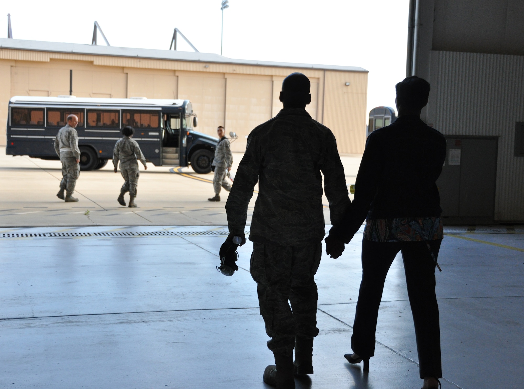 U.S. Air Force Tech. Sgt. James Brown, 459th Maintenance Squadron, walks hand-in-hand with his significant other as he gets ready to board a bus which will take him and his squadron to a KC-135 Stratotanker for a deployment departure at Joint Base Andrews, Md., May 13, 2013. The 459th MXS and Operations Group deployed to an undisclosed location in Southwest Asia in support of Operation Enduring Freedom. (U.S. Air Force photo/ Staff Sgt. Katie Spencer)