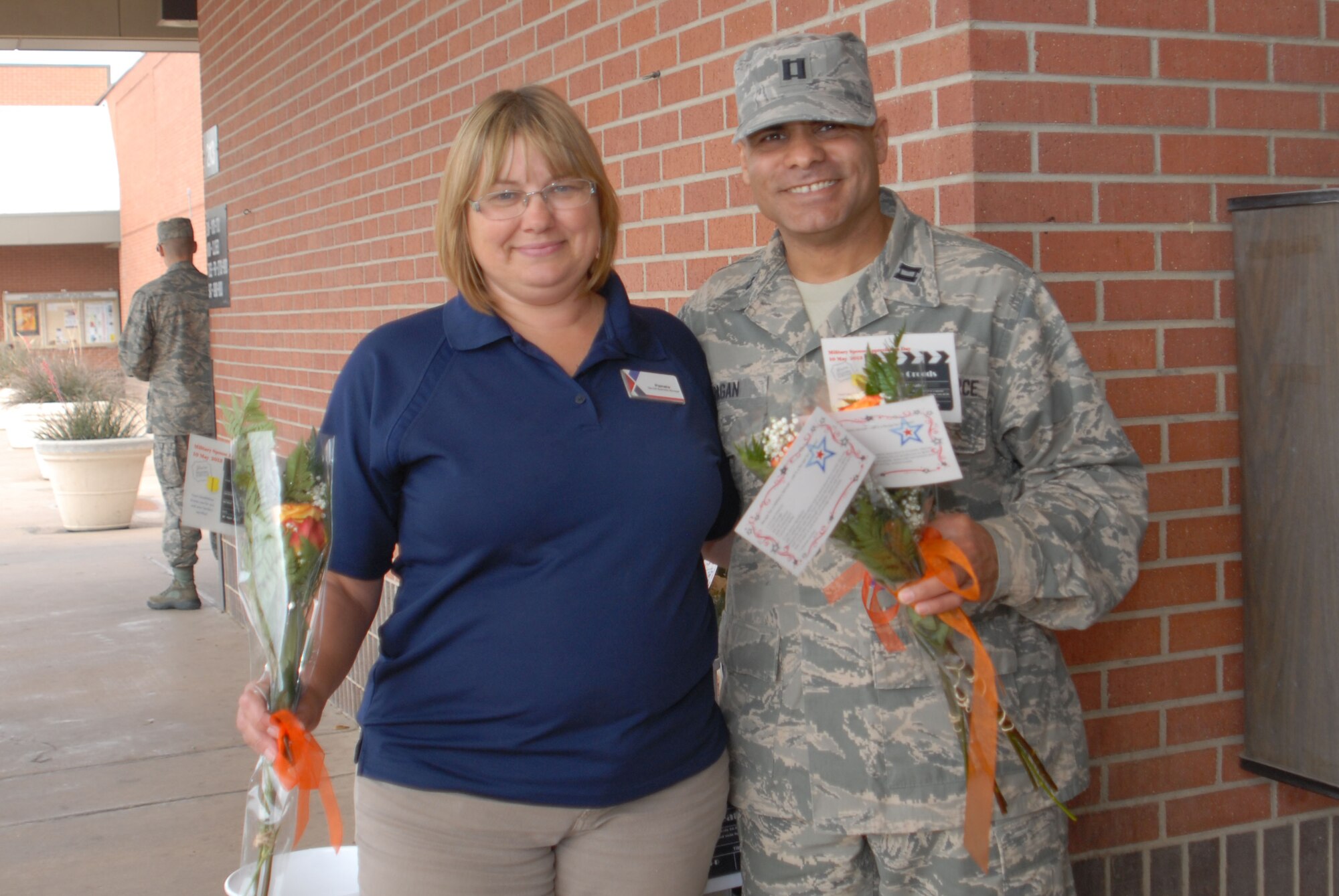 GOODFELLOW AIR FORCE BASE, Texas -- Chaplain (Capt.) Victor Pagan, 17th Training Wing, presents a rose to Pamela Hunter, the base flower shop manager outside of the base Commissary, May 10. Military Spouse Appreciation Day falls on the Friday before mother's day and emphasizes the hard work and sacrifices made by military spouses and is only one of the many ways the military shows its support. (U.S. Air Force photo/ A1C Breonna Fields) 