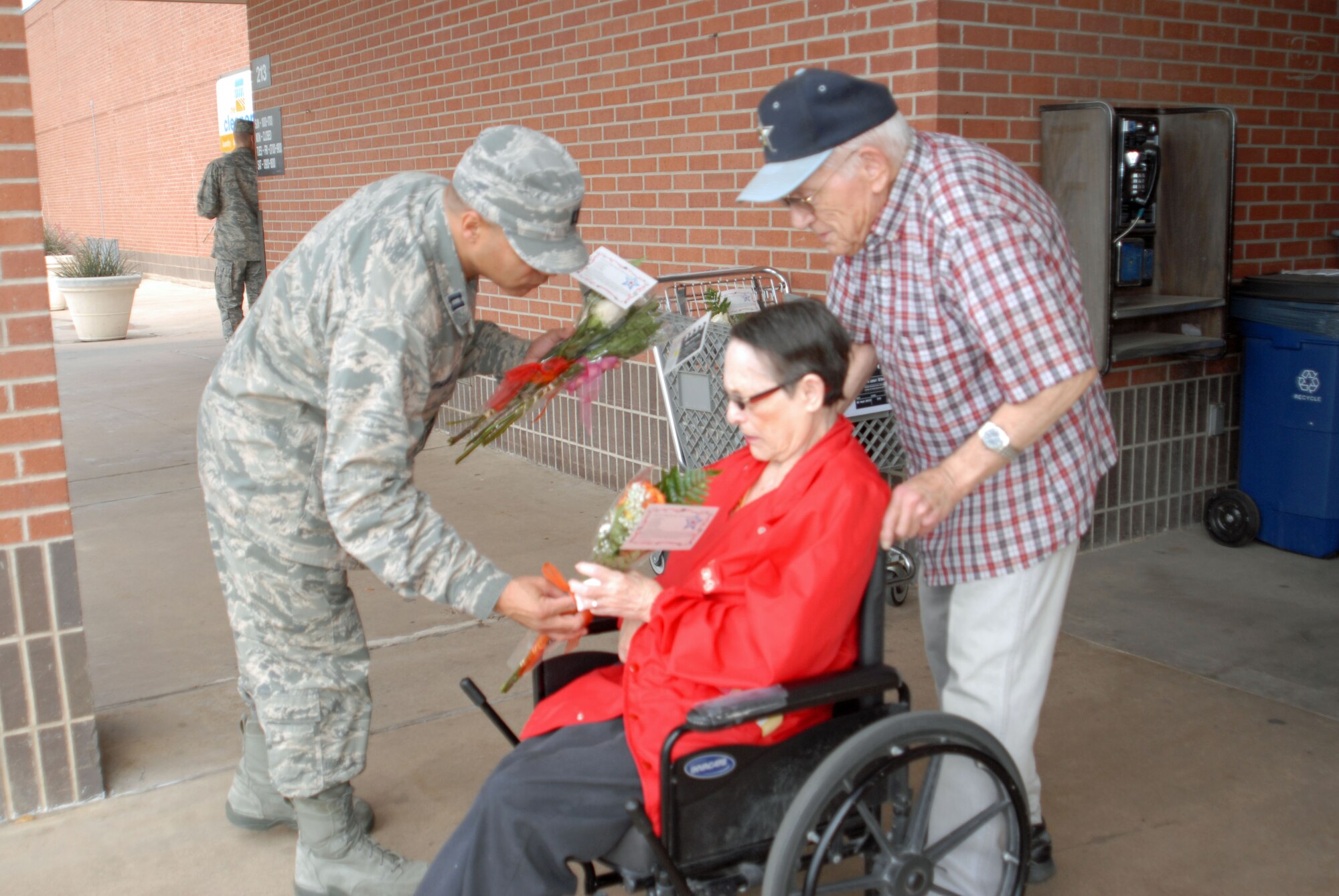 GOODFELLOW AIR FORCE BASE, Texas – Chaplain (Capt.) Victor Pagan, 17th Training Wing, presents roses, provided by the base flower shop, to military spouses as they leave the Commissary, May 10. Military Spouse Appreciation Day falls on the Friday before mother's day and emphasizes the hard work and sacrifices made by military spouses and is only one of the many ways the military shows its support. (U.S. Air Force photo/ A1C Breonna Fields) 