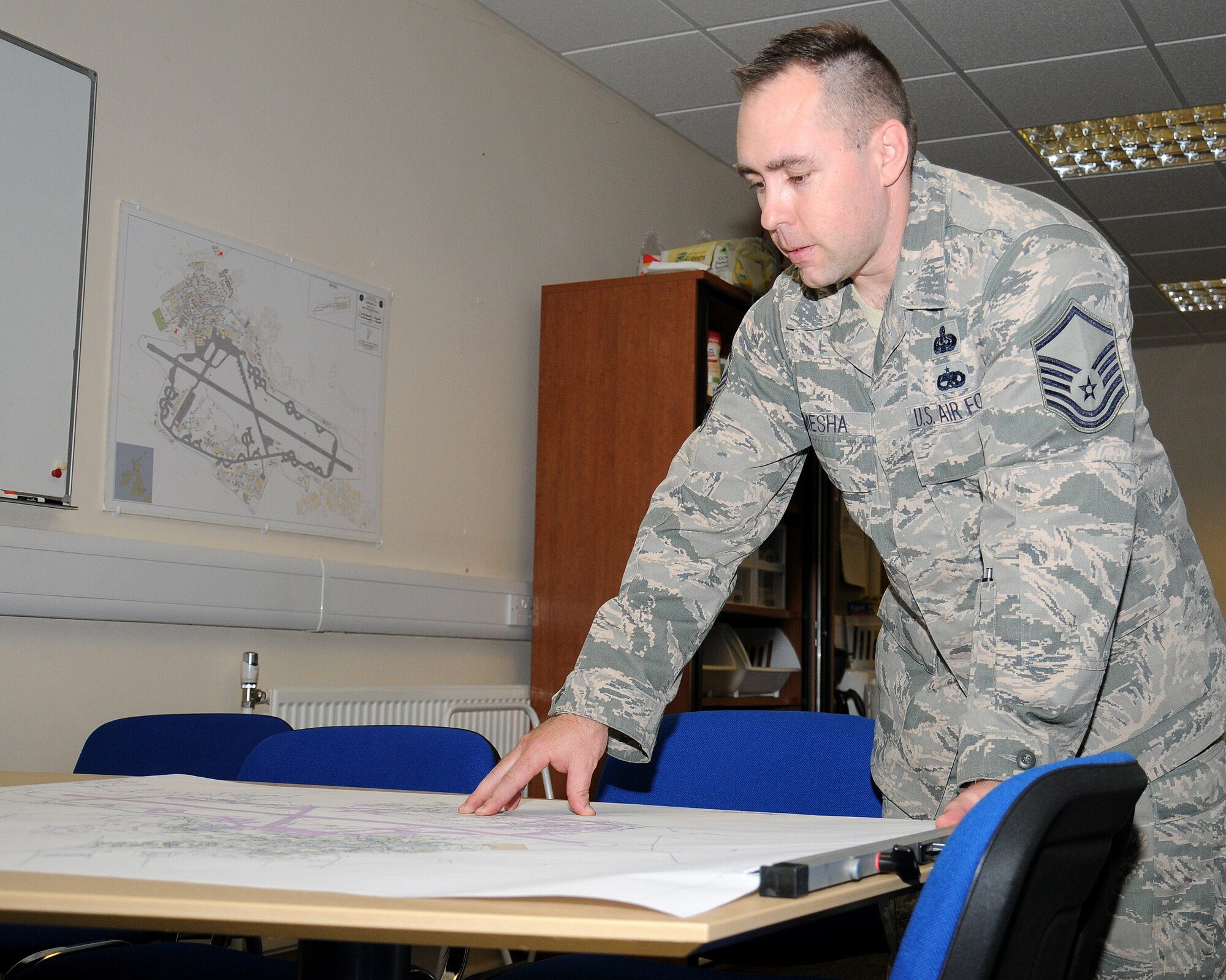Master Sgt. Travis Romesha, 100th Communication Squadron Plans, Programs and Resources section chief from Lake City, Calif., gathers information from a communications and information systems installation records map during project planning May 7, 2013, at RAF Mildenhall, England. The 100th CS maintains more than 760 drawings and maps as part of their CSIR. The CSIR program is used in planning for communication requirements and project planning. (U.S. Air Force photo by Gina Randall/Released)