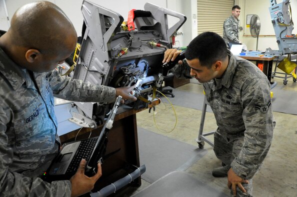 Senior Airman Jonathan Gerald and Airman 1st Class Stefan Isaza, 35th Maintenance Squadron egress journeymen, inspect an ejection seat for any irregularities at Misawa Air Base, Japan, April 25, 2013. The 35th Maintenance Group received passing scores after a week of Logistics Compliance Assessment Program inspections evaluating their daily jobs. (U.S. Air Force photo by Airman 1st Class Kaleb Snay)