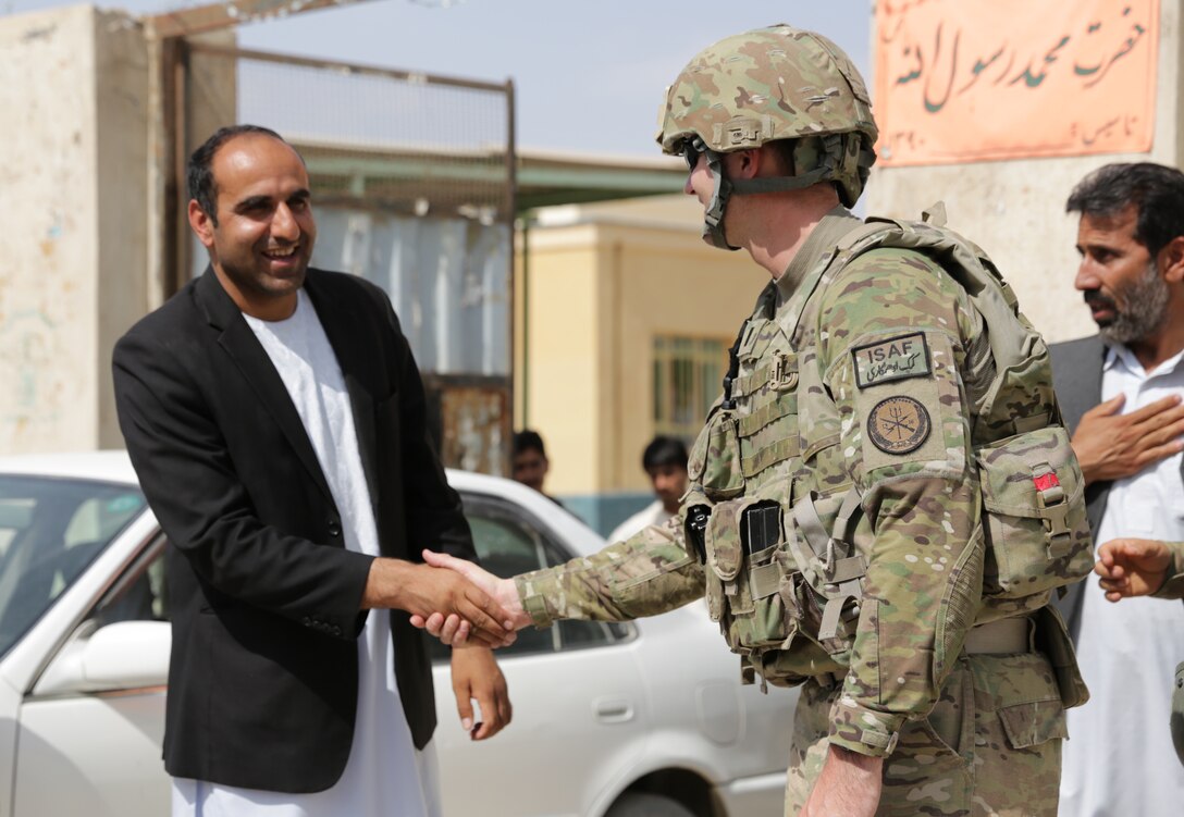 U.S. Navy Lt. j.g. Matthew Stroup, right, shakes hands with Farah provincial education director Mohammed Saber, at the conclusion of their meeting at Aboonaser Farahi high school in Farah City, Afghanistan, May 13, 2013. Stroup, a public affairs officer, is assigned to Provincial Reconstruction Team Farah.