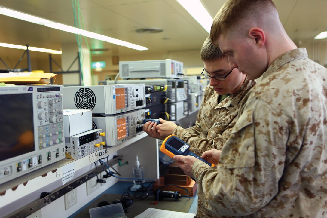 Lance Cpl. Justin W. Ivie, background, and Lance Cpl. Timothy R. Smith, test the fiber optics of the light-wave measurement system May 9 at the 3rd Maintenance Battalion calibration lab on Camp Kinser. Smith and Ivie are calibration technicians with 3rd Maintenance Bn., Combat Logistics Regiment 35, 3rd Marine Logistics Group, III Marine Expeditionary Force. Photo by Lance Cpl. Jose D. Lujano