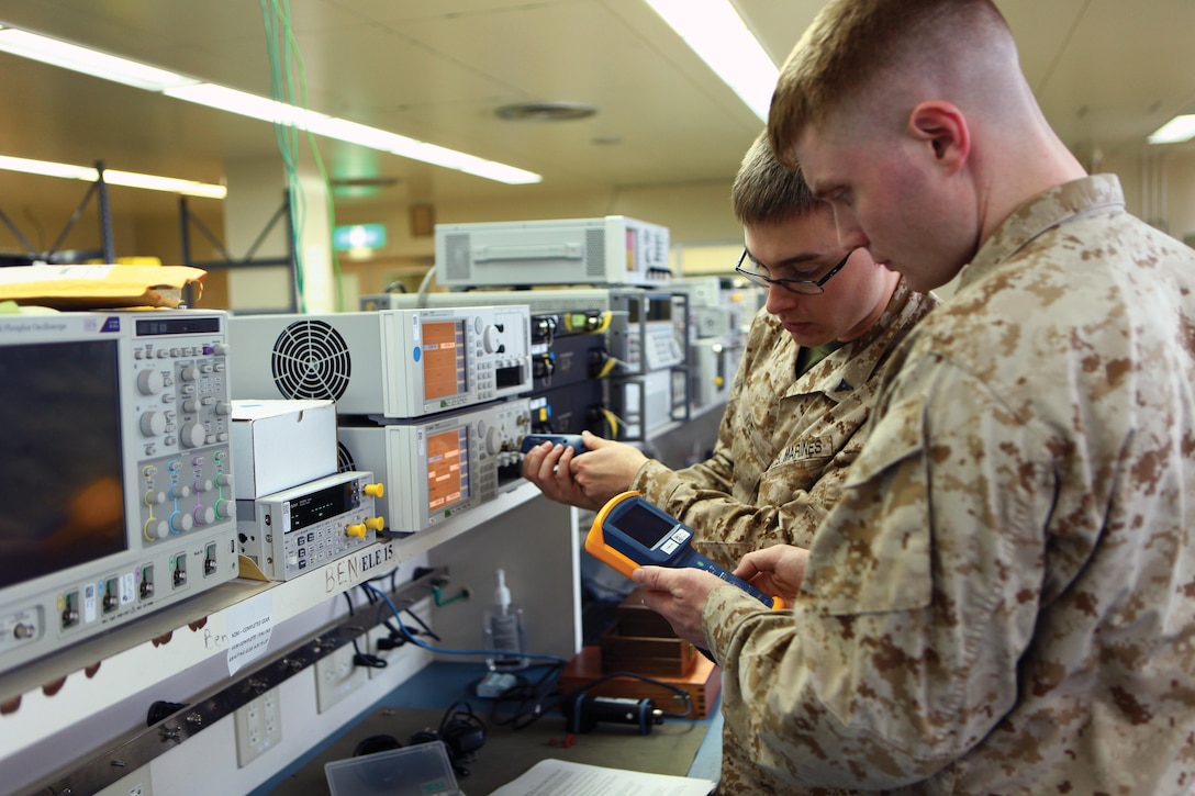 Lance Cpl. Justin W. Ivie, background, and Lance Cpl. Timothy R. Smith, test the fiber optics of the light-wave measurement system May 9 at the 3rd Maintenance Battalion calibration lab on Camp Kinser. Smith and Ivie are calibration technicians with 3rd Maintenance Bn., Combat Logistics Regiment 35, 3rd Marine Logistics Group, III Marine Expeditionary Force. Photo by Lance Cpl. Jose D. Lujano