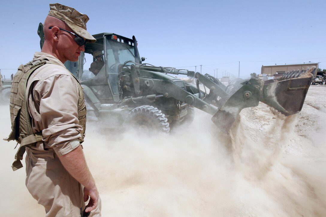 U.S. Marine Sgt. Aaron J. Mahar, left, a project manager, supervises Lance Cpl. William T. Warren, a heavy equipment operator, both with Marine Wing Support Squadron 271 (MWSS-271), operate a Caterpiller 420D backhoe loader at Camp Shorabak, Helmand province, Afghanistan, May 15, 2013. Marines with MWSS-271 assisted the Afghan National Army with the reconstruction and improvement of the friendship gate. (U.S. Marine Corps photo by Cpl. Ashley E. Santy/Released)