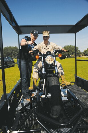 Maj. Paulina Rojas with Marine Corps Logistics Command learns the basics of a motorcycle during hands-on training at Marine Corps Logistics Command’s biannual safety stand-down at the “101 Critical Days of Summer,” May 9 at Covella Pond. The event provided details on motorcycle safety, private motor vehicle safety, recreational vehicle safety, boats and watercraft safety, and more to reduce or minimize injuries and/or fatalities.