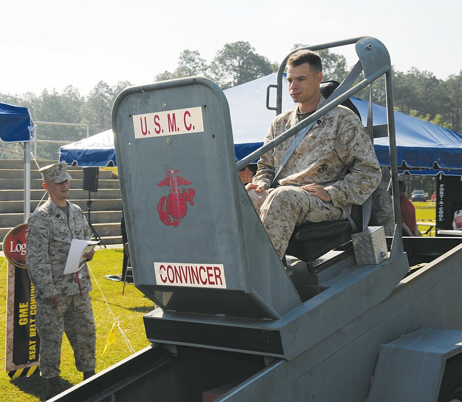 Gunnery Sgt. William Lyman, Marine technical specialist with the Weapons Systems Management Center, Marine Corps Logistics Command, ride in the convincer, which simulates a motor vehicle crash at about 10 miles an hour while wearing a seatbelt.