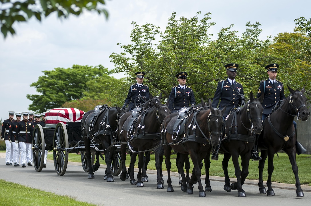 A horse-drawn caisson followed by Marine Corps body bearers from Marine Barracks Washington, D.C. travel through Arlington National Cemetary toward the burial site, May 15. The Barracks supported the ceremony, in which 13 servicemembers were buried and repatriated on the 38th anniversary of the May 15, 1975 helicopter crash on Koh Tang Island, Cambodia. The servicemembers perished while on a mission to rescue the SS Mayaguez crew, who were captured by the Khmer Rouge.