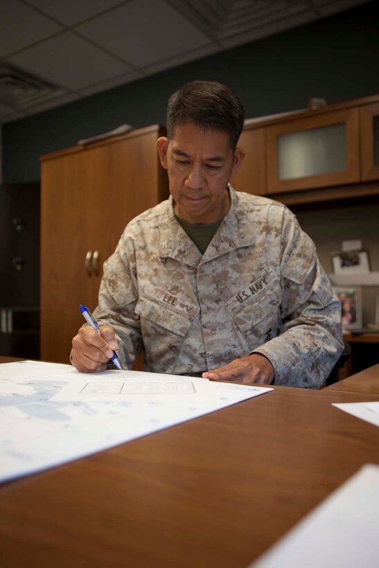 Navy Capt. Guy Lee, 1st Marine Division chaplain and a San Francisco native, examines rosters of sailors and Marines here, May 14, 2013. Under Marine Administrative Message 075/13, the increases of Military and Family Life Consultants are at no cost to the Marine Corps and solely funded by the Department of Defense. Chaplains and MFLCs work together in a new program that gives Marines and sailors an opportunity to develop coping skills for a variety of military and family challenges with short-term, nonmedical and solution-focused counseling.