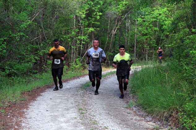 Participants of the infamous “Mud, Seat and Tears Run” sponsored by U.S. Marine Corps Forces, Special Operations Command, endure an intense trail filled with forest terrain, winding trails, fallen trees and giant mud pits April 27, 2013. The run consisted of a five-mile trek through the woods and muddy terrain of Stone Bay. 