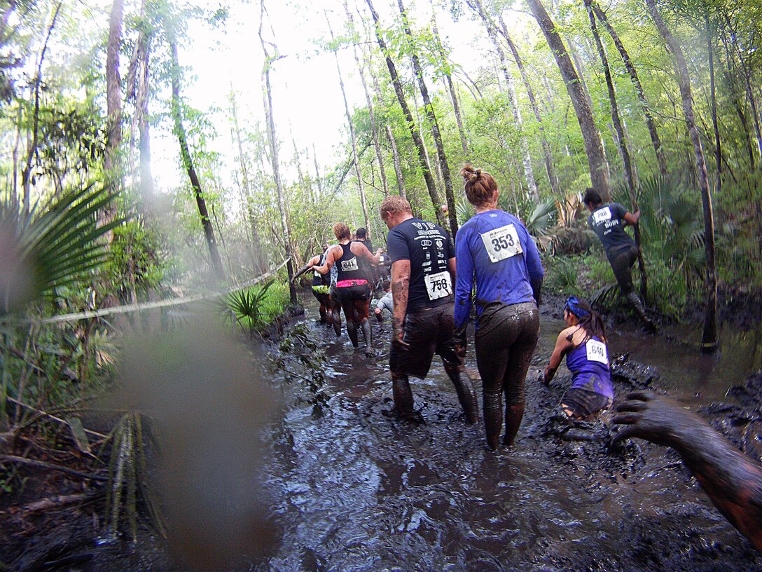 Participants of the infamous “Mud, Seat and Tears Run” sponsored by U.S. Marine Corps Forces, Special Operations Command, endure an intense trail filled with forest terrain, winding trails, fallen trees and giant mud pits April 27, 2013. The run consisted of a five-mile trek through the woods and muddy terrain of Stone Bay. 