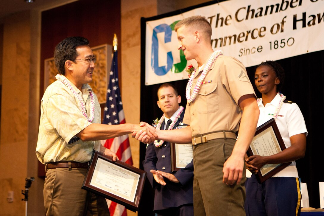 Ku'uhaku Park, the Matson Inc. vice president of government and community relations, presents a certificate of excellence to Lance Cpl. Cody A. Jones, landing support specialist in Combat Logistics Battalion 3, here May 9 during the Hawaii Military Appreciation Month Recognition Luncheon. Jones received the award for his outstanding contribution to the community, logging 775 volunteer hours in a six-month period teaching children in the gymnastics program at K-Bay Gymnastics on Marine Corps Base Hawaii, and giving swim lessons to children. Jones was also the third runner-up for the MCBH community service award. 