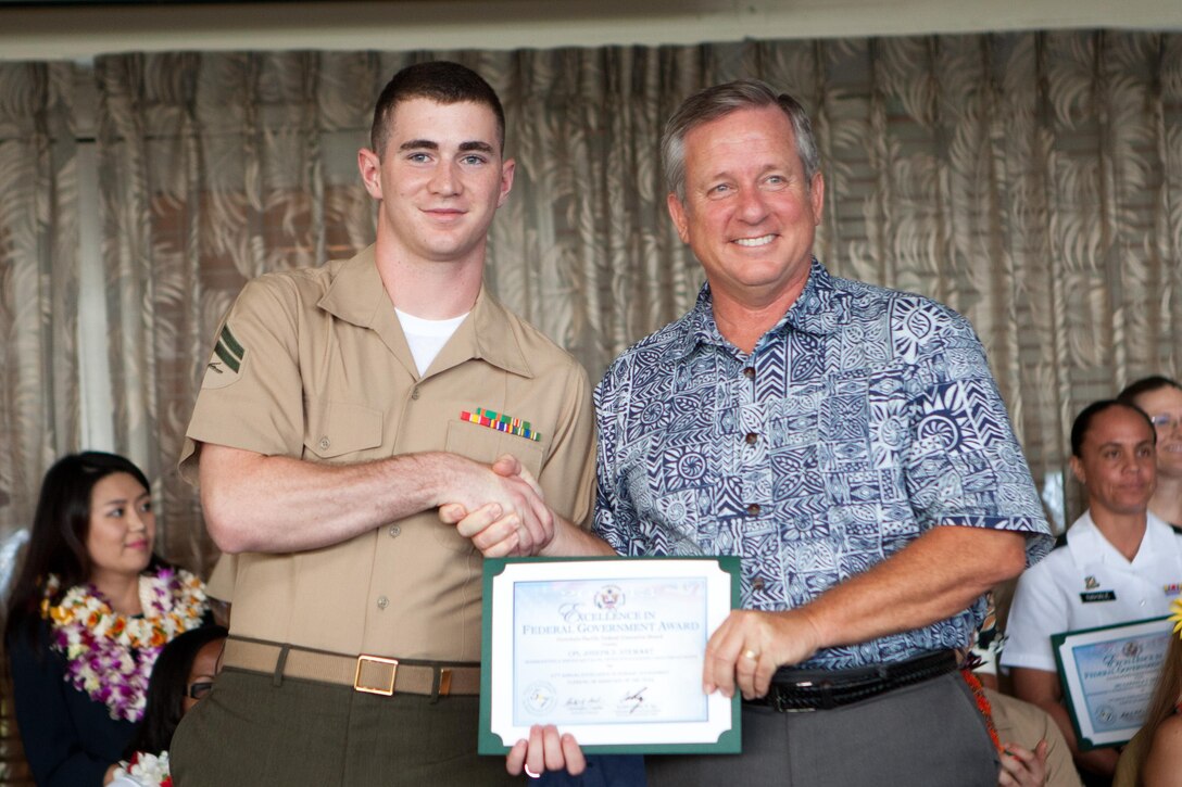 Craig Whelden (right), executive director of U.S. Marine Corps Forces, Pacific, presents Cpl. Joseph Stewart, an administrative clerk at Headquarters and Service Battalion, MarForPac, with an Employee of the Year award in the clerical and assistant category of the 2013 Excellence in Federal Government Awards here May 10. Other members of MarForPac who also received recognition at the awards were Nanette Asam with the staff judge advocate office and John Reitz, Christopher Mohr and Staff Sgt. Laura Maguire, with the operations section. 