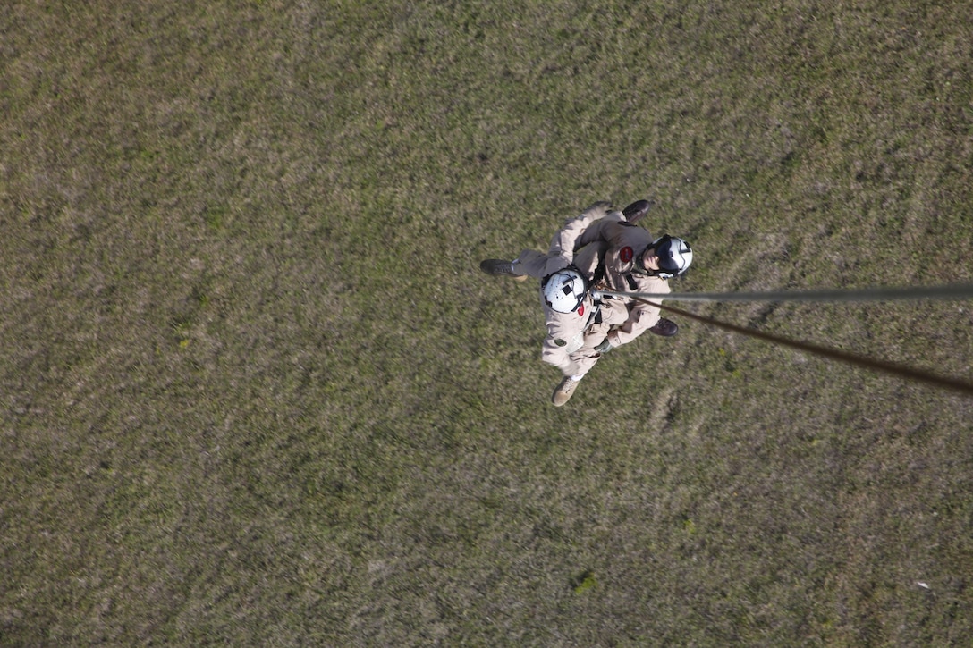 Petty Officer 2nd Class Adam Woolley, a hospital corpsman, and Cpl. Kyle B. Smith, a rescue swimmer with VMR-1, rappel from an HH-46E Sea Knight affectionately referred to as “Pedro,” during rappel currency training May 10.
