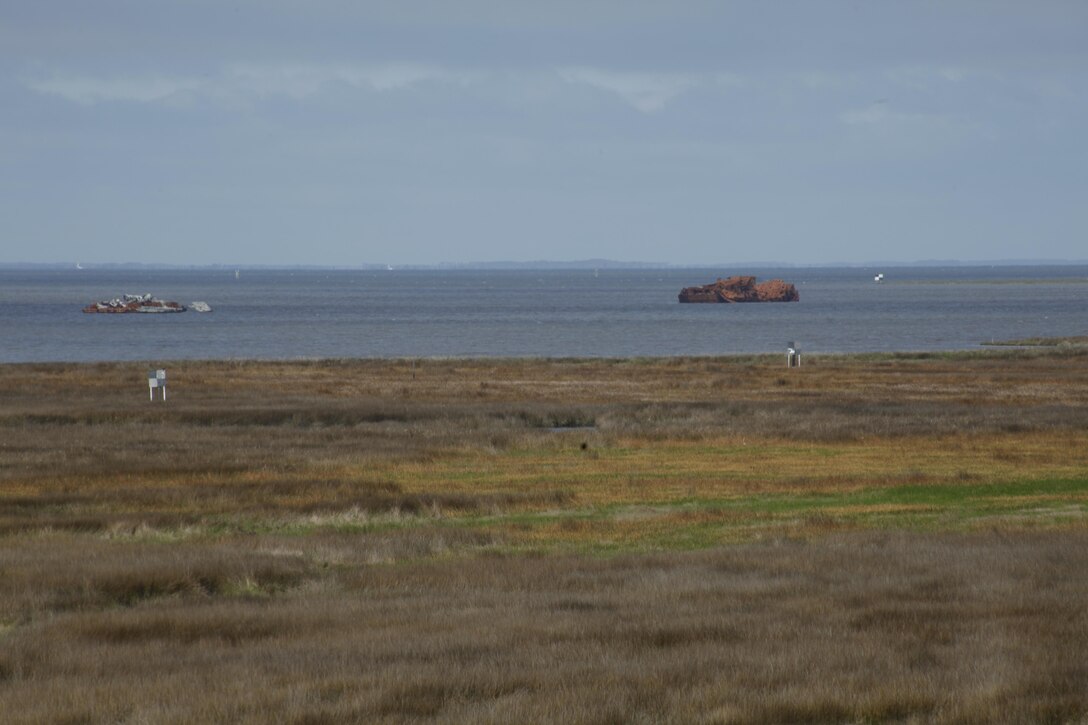 Two target barges at BT-9 float in ruins in South Bay of Piney Island May 1. The bombing range helps pilots hone their skill in attacking various types of targets, including ships.