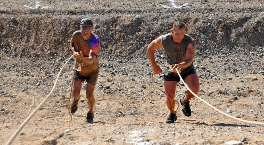 Gunnery Sergeants Chad Webb and Russell Garcia, Marines on Marine Corps Logistics Base Barstow, Calif., climb up an obstacle during the second annual Barstow Mud Run held May 11 at the city’s local sports complex. The Marine Corps’ daily physical training keeps its members conditioned to participate in mud runs and other obstacle races in their free time.
