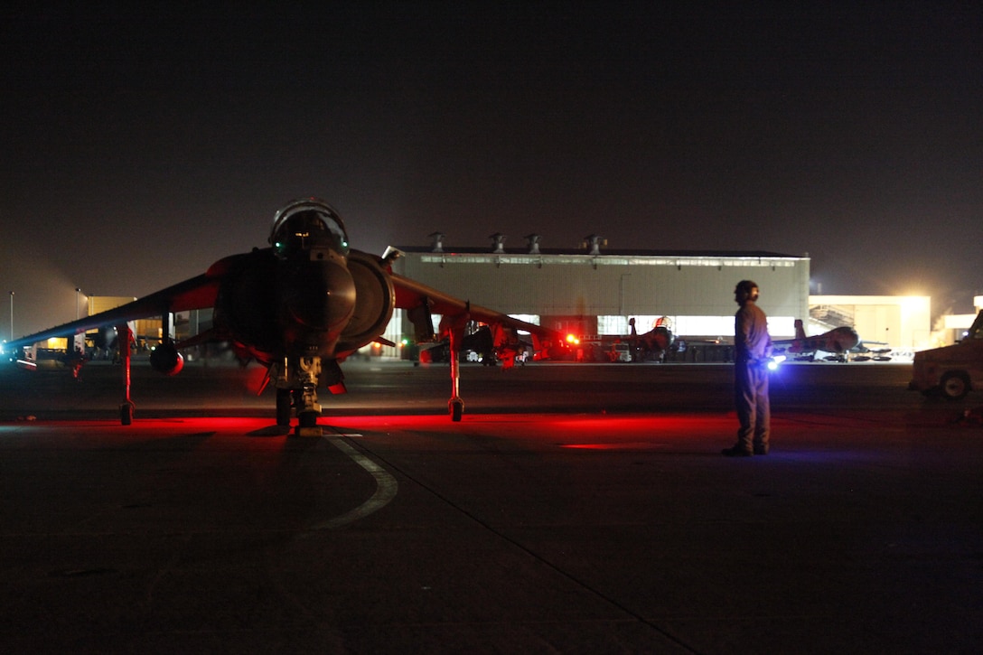 A Marine Attack Squadron 542 plane captain guides an AV-8B Harrier in for parking after completing a training mission May 9 at Cherry Point. Maintenance Marines enable aircraft to fly and perform missions at any time of day.
