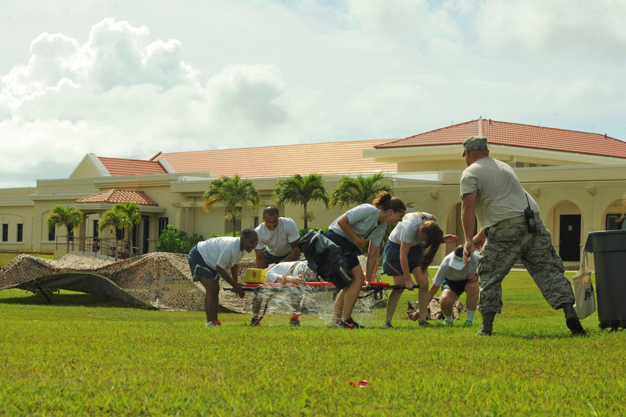 Airmen from the 36th Medical Group come under attack by water balloons while transporting a dummy to safety during training on Andersen Air Force Base, Guam, May 8, 2013. The 36th MDG held combat-based training as part of National Nurse Week, May 6-12. The nurses and technicians trained on assessing patients, CPR, care under fire and other SABC tasks. (U.S. Air Force photo by Senior Airman Robert Hicks/Released)
