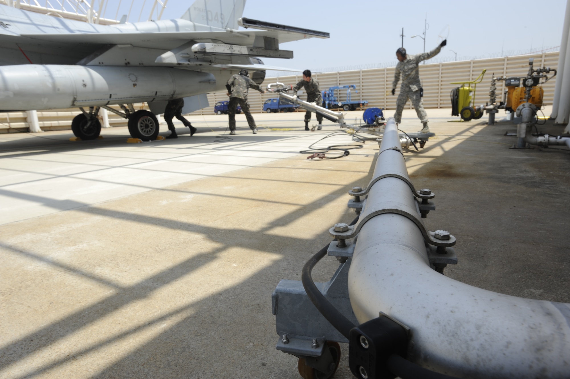 KUNSAN AIR BASE, Republic of Korea – Republic of Korea air force maintainers from the 38th Fighter Group uses a pantograph arm to pump JP-8 into a ROKAF KF-16 Fighting Falcon, while Senior Airman Jamar Huggins, 8th Logistics Readiness Squadron petroleum, oil and lubricants technician untangles a grounding cable to prevent a tripping hazard at Kunsan Air Base, Republic of Korea, May 6, 2013. This was the second such hot pit refueling operation between the 8th Logistics Readiness Squadron and ROKAF maintainers.  (U.S. Air Force photo by Staff Sgt. Tong Duong/ Released)