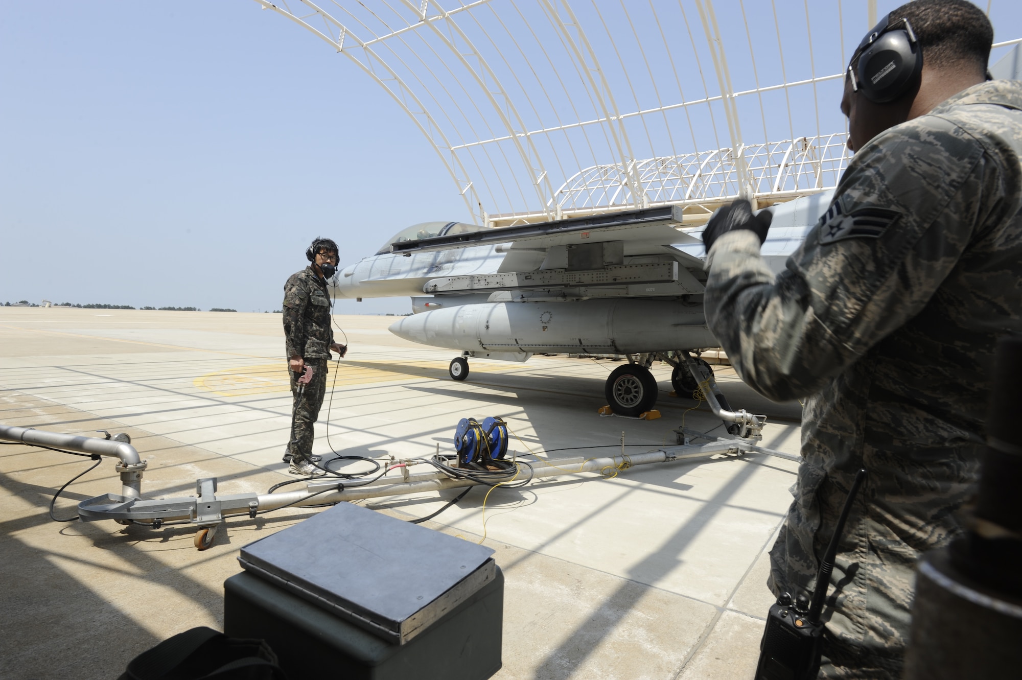 KUNSAN AIR BASE, Republic of Korea – Republic of Korea air force, Tech. Sgt. Sang Min Jo, 38th Fighter Group maintainer keeps an eye on the amount of JP-8 being pumped into a ROKAF KF-16 Fighting Falcon, while Senior Airman Jamar Huggins, 8th Logistics Readiness Squadron petroleum, oil and lubricants technician keeps log, during a hot pit refueling operation at Kunsan Air Base, Republic of Korea, May 6, 2013. The JP-8 was delivered from an offsite pumping station through the underground fuel hydrant system to the pantograph arm, which aircraft maintainers use to fill up a aircraft.  (U.S. Air Force photo by Staff Sgt. Tong Duong/ Released)