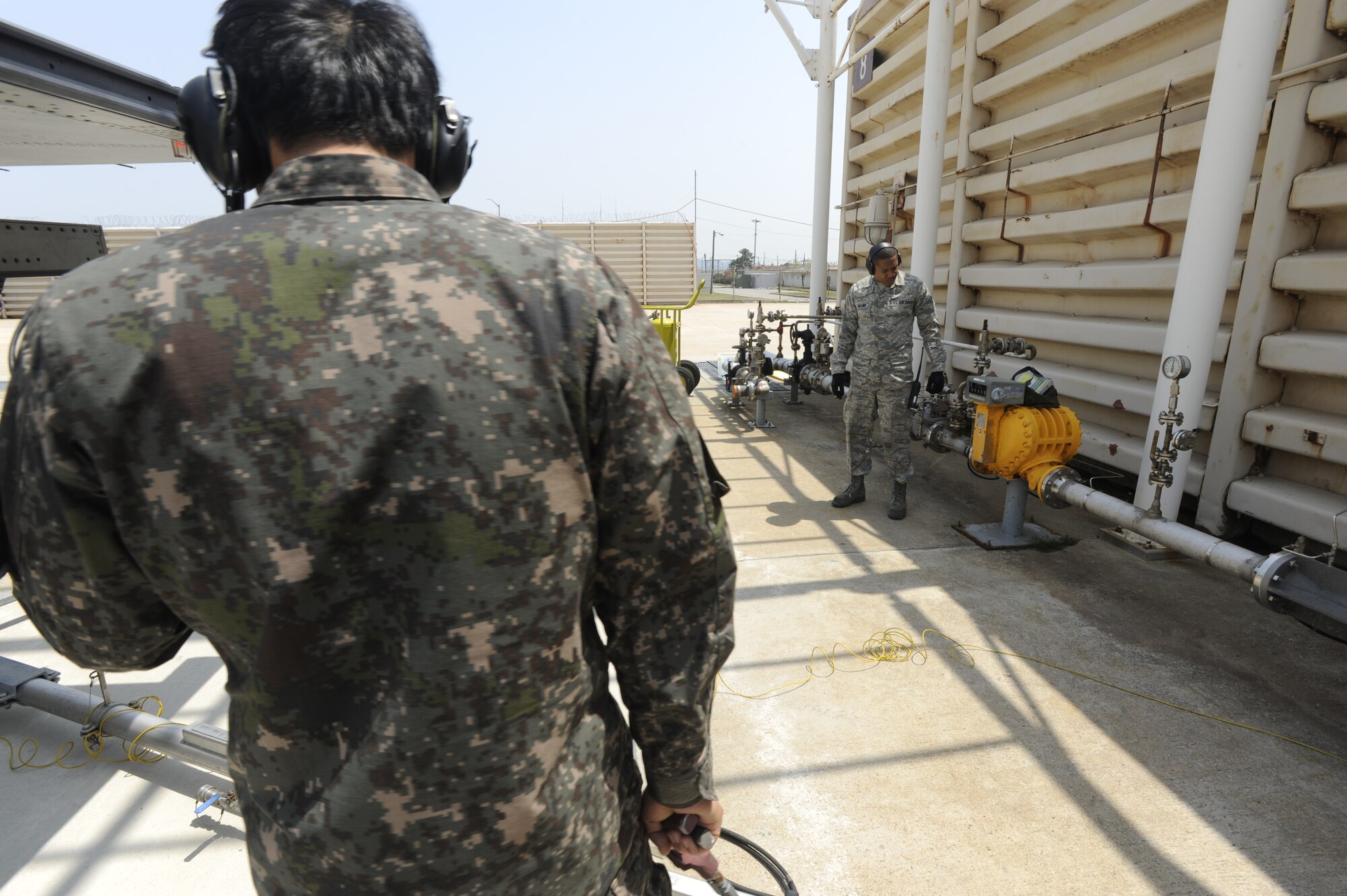 KUNSAN AIR BASE, Republic of Korea – Republic of Korea air force, Tech. Sgt. Sang Min Jo, 38th Fighter Group maintainer refuels a running ROKAF KF-16 Fighting Falcon, while Senior Airman Jamar Huggins, 8th Logistics Readiness Squadron petroleum, oil and lubricants technician watches the fuel meter, during a hot pit refueling operation at Kunsan Air Base, Republic of Korea May 6, 2013. Huggins, the refueling operations supervisor not only monitored the fuel flow, but was on hand to seize operations in case of a spill.  (U.S. Air Force photo by Staff Sgt. Tong Duong/ Released)
