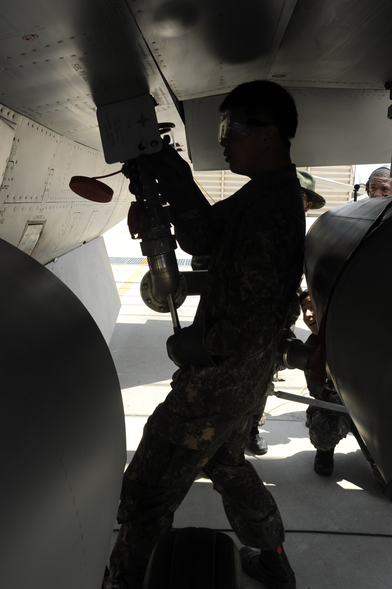 KUNSAN AIR BASE, Republic of Korea – Republic of Korea air force, Staff Sgt. Keun Ha Kang, 38th Fighter Group maintainer attaches a fuel nozzle to a ROKAF KF-16 Fighting Falcon during a hot pit refueling operation at Kunsan Air Base, Republic of Korea May 6, 2013. Senior Airman Jamar Huggins, 8th Logistics Readiness Squadron petroleum, oil and lubricants technician kept watch to ensure the refueling operations went smoothly. (U.S. Air Force photo by Staff Sgt. Tong Duong/ Released)