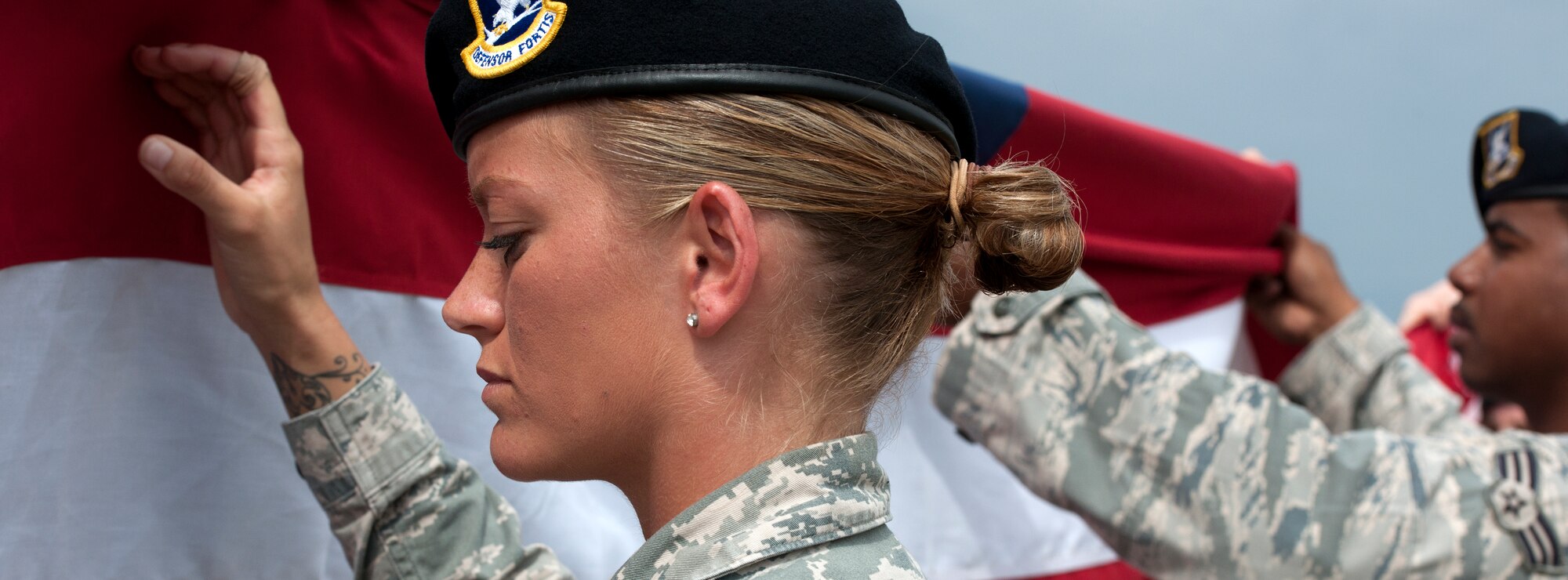 ALTUS AIR FORCE BASE, Okla. – Senior Airman Juliane Breault, 97th Security Forces Squadron patrolman, join other members of the 97th Security Forces Squadron in a flag folding ceremony during retreat in observance of National Police Week at Wings of Freedom Park, May 15. National Police Week is a collaborative effort of many organizations dedicated to honoring America's law enforcement community. (U.S. Air Force photo by Senior Airman Jesse Lopez / Released)