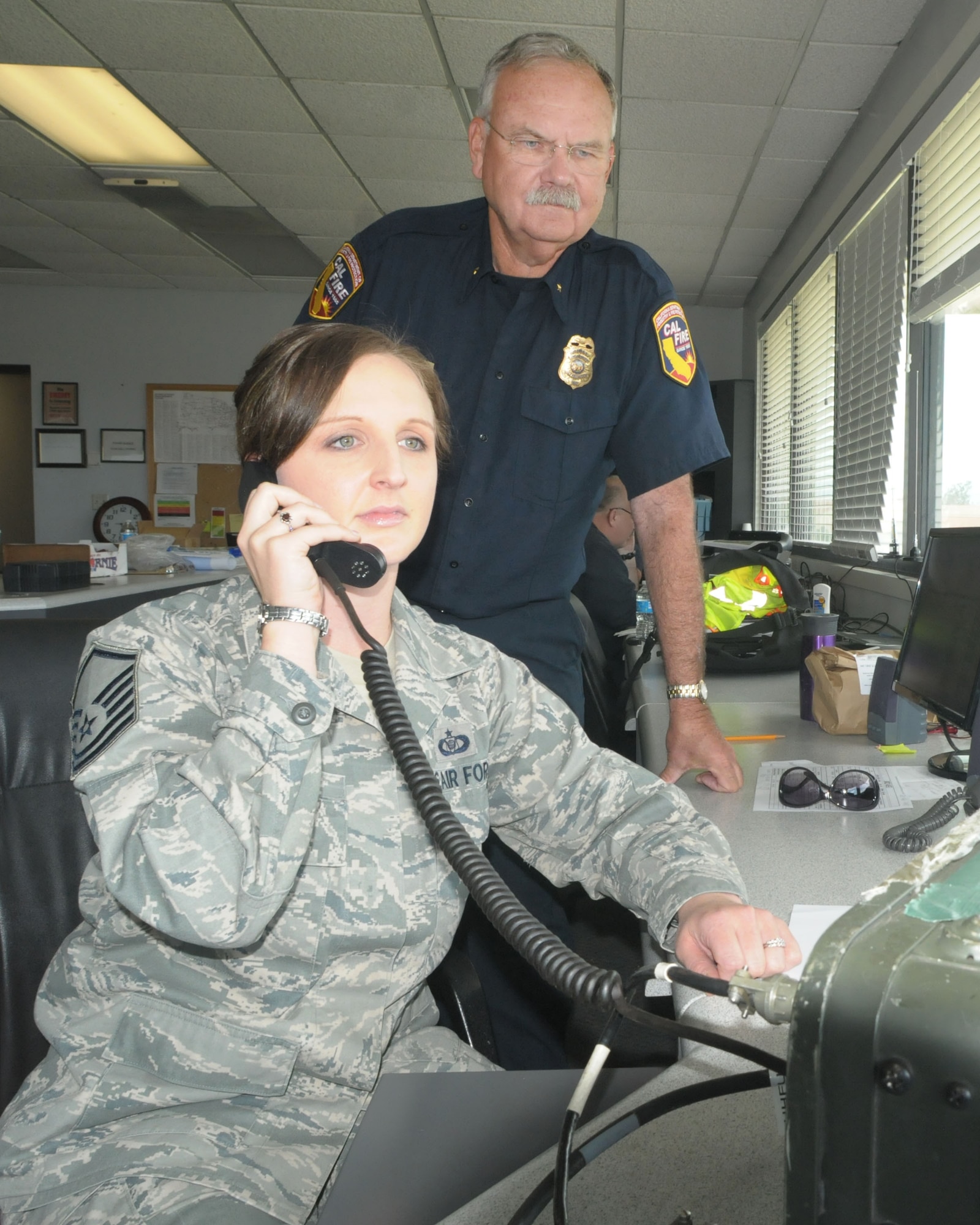 Master Sgt. Amy Zuniga from the 146th Airlift Wing and CAL FIRE officer Dan Sendek coordinate movement and reloading of CAL FIRE aircraft at the air tanker base staging out of Channel Islands Air National Guard Base in Port Hueneme, Calif. Two C130J firefighting aircraft and the146th Airlift Wing's ramp were requested by CAL FIRE to be used as an air tanker base for civilian and military aircraft to reload with retardant fighting Spring fire in Ventura County and other wildfires in the region. (U.S. Air National Guard photo by Senior Airman Nicholas Carzis)