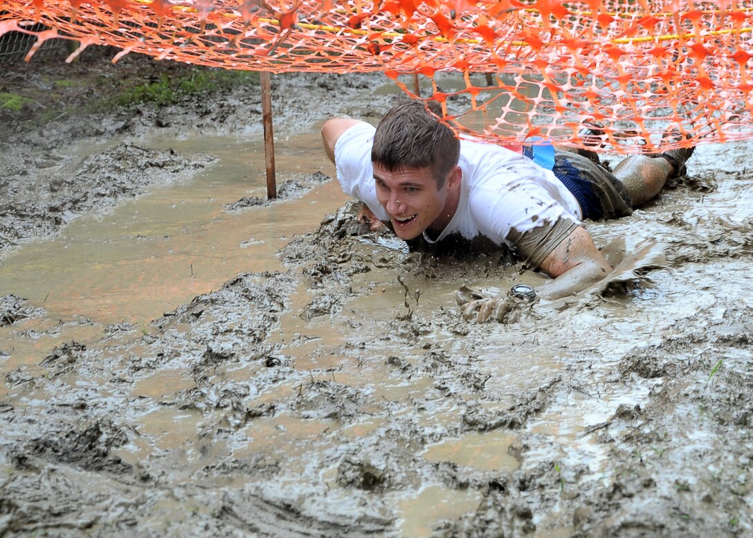 A Zombie Run participant low crawls through the mud during the Zombie Run held on Columbus Air Force Base May 11. Runners were expected to low crawl under netting after escaping from an onslaught of zombies. (U.S. Air Force photo/ Airman 1st Class Stephanie Englar)