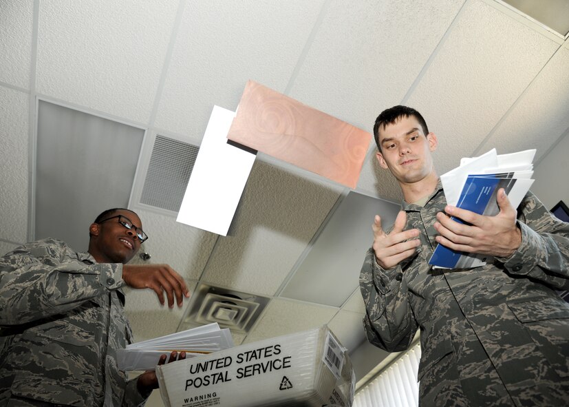 (From left) Airmen 1st Class Roger Miller and Kyle Elbie, 319th Communications Squadron official mail technicians, toss mail into a bin prior to it being sorted on May 13th, 2013, on Grand Forks Air Force Base, N.D. Members of the official mail center delivered more than 13,000 letters to 22 units in the past year. (U.S. Air Force photo/Airman 1st Class Ashley Nicole Taylor)
