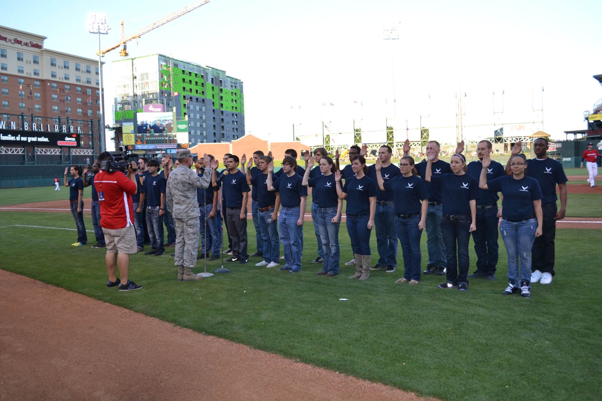 Col. Matthew C. Harris, 3rd Combat Communications Group commander, swears-in 30 Air Force recruits as one of the many different events happening at the May 11 Oklahoma City RedHawks Hometown Hero Celebration Night. Colonel Harris also threw out the ceremonial first pitch, welcomed home deployed Airmen, addressed the crowd with an inspiring speech and did a radio interview with the RedHawks radio announcer Alex Freeman. (Air Force photo by Kathy E. Paine)